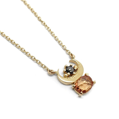 10kt yellow gold necklace with crescent moon, orange sapphire, and hexagon salt and pepper diamond
