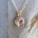 10kt yellow gold pendant with oval peach morganite on a silver chain, shown against stone
