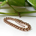 14K rose gold vintage curb link bracelet displayed with greenery