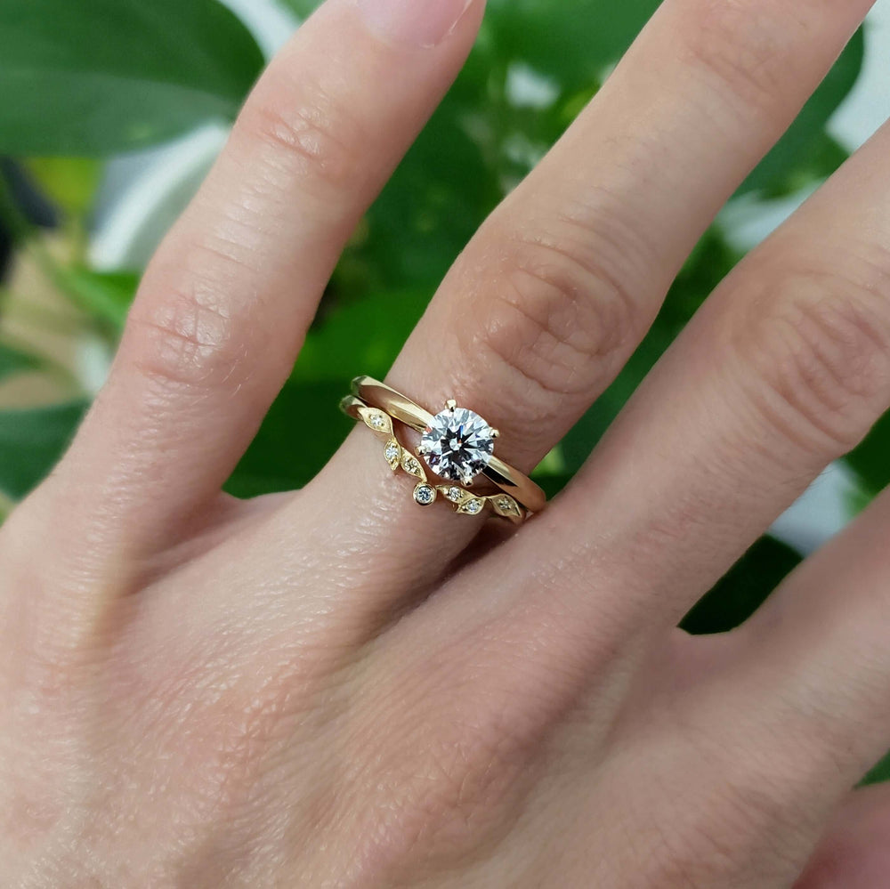 14k gold diamond leaf wedding ring stacked with solitaire engagement ring on hand