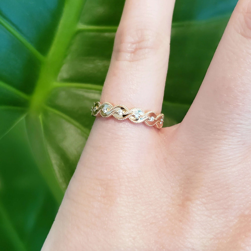 14k rose gold diamond millgrain wedding band shown on hand