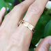 14k rose gold mountain range wedding ring worn on a hand, high polished finish