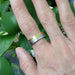 14k white and yellow gold mountain range wedding ring shown on hand