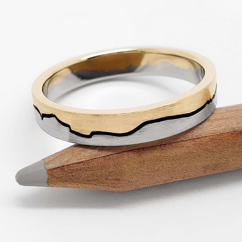 14k white and yellow gold mountain range wedding ring with blackened groove on pencil