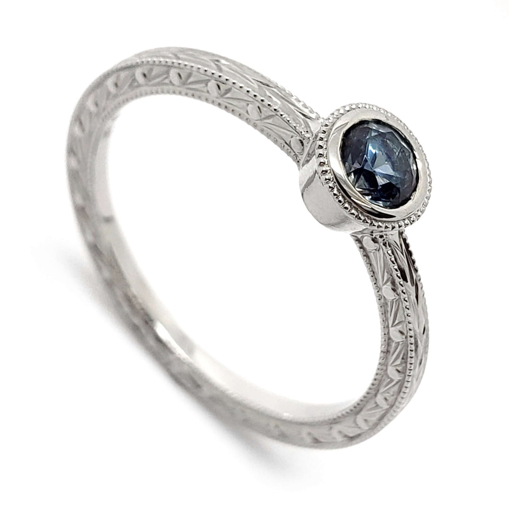 14k white gold engagement ring with blue-grey Montana sapphire and hand engraving