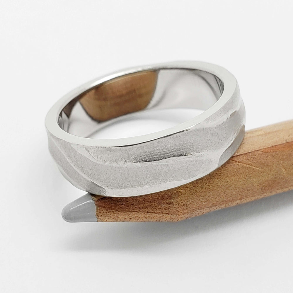 14k white gold topography wedding band with carved texture on a wooden pencil