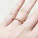 14k yellow gold champagne diamond wedding band worn on a hand