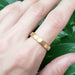 14k yellow gold flat wedding ring with brushed finish shown on a hand