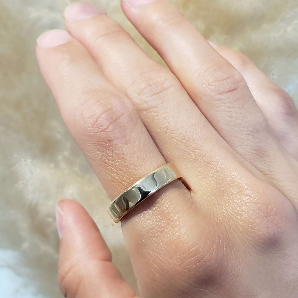 14k yellow gold flat wedding ring worn on hand