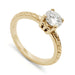 14k yellow gold engagement ring with round moissanite and wheat engraving on band