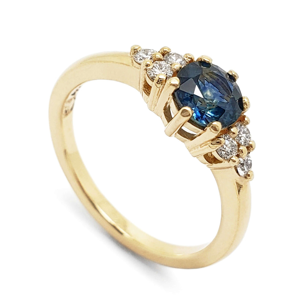 14k yellow gold ring with round blue Montana sapphire and Canadian diamonds, angled view
