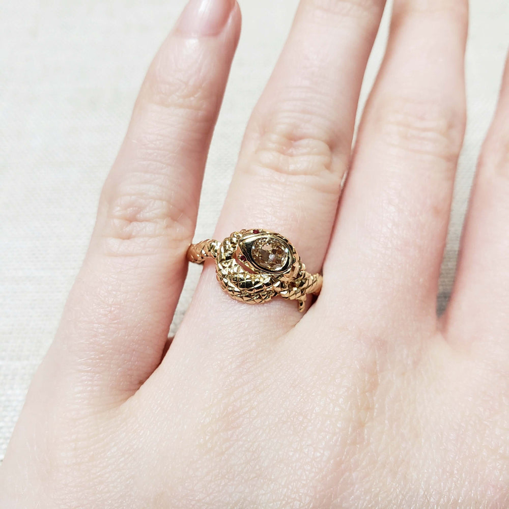 14k yellow gold snake ring with champagne diamond and rubies, worn on hand