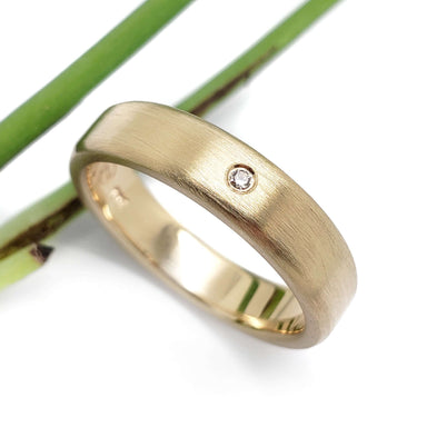 14k yellow gold wedding band with a single flush-set Canadian diamond, brushed texture