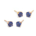 Pair of round tanzanite stud earrings in 14kt gold four-claw settings on white background