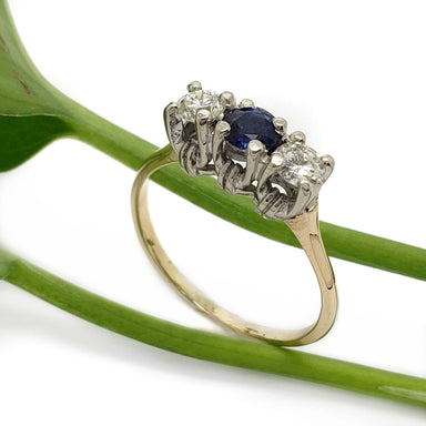 14kt yellow and white gold three-stone ring with sapphire and diamonds on a green stem