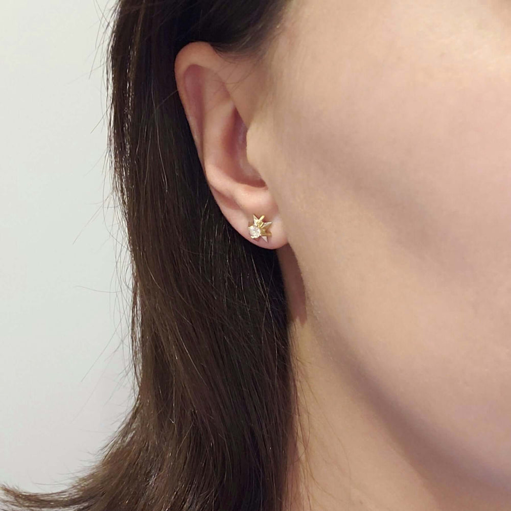 Vintage diamond starburst stud earring in 14kt yellow and white gold worn on ear
