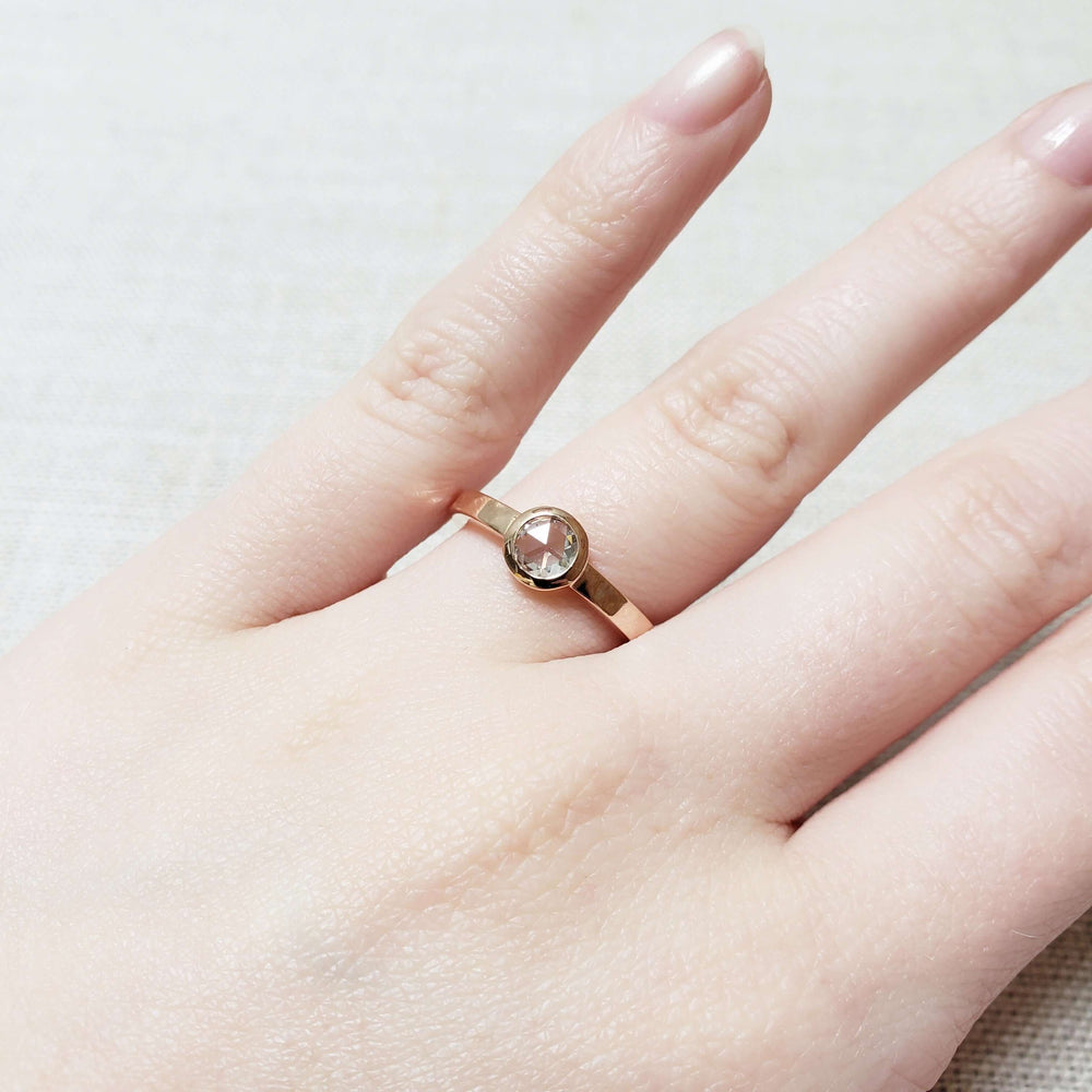 14kt rose gold bezel-set diamond ring worn on hand