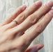 14kt rose gold chevron wedding ring with hand engraving shown on a hand