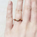 14kt rose gold chevron wedding ring with millgrain, worn on a hand
