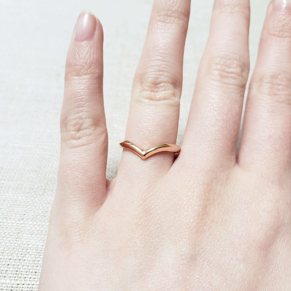 14kt rose gold chevron wedding ring worn on a hand