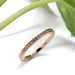 14kt rose gold diamond pave wedding ring beside green leaves