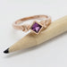 14kt rose gold engagement ring with purple sapphire, displayed on a pencil