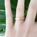 14kt rose gold flat wedding band with saw blade finish shown on a hand