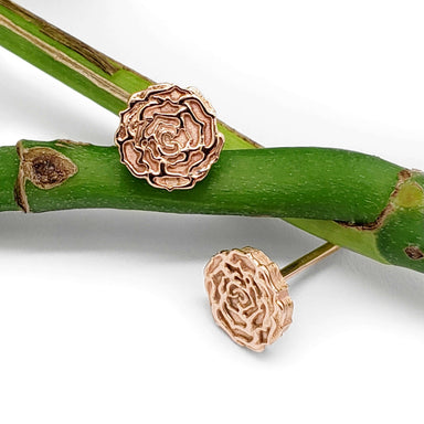 14kt rose gold floral stud earrings displayed on green bamboo stem
