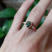 14kt rose gold green sapphire and diamond engagement ring shown on a hand