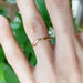 14kt rose gold leaf and twig wedding ring shown on hand