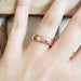 14kt rose gold millgrain wedding ring shown on a hand