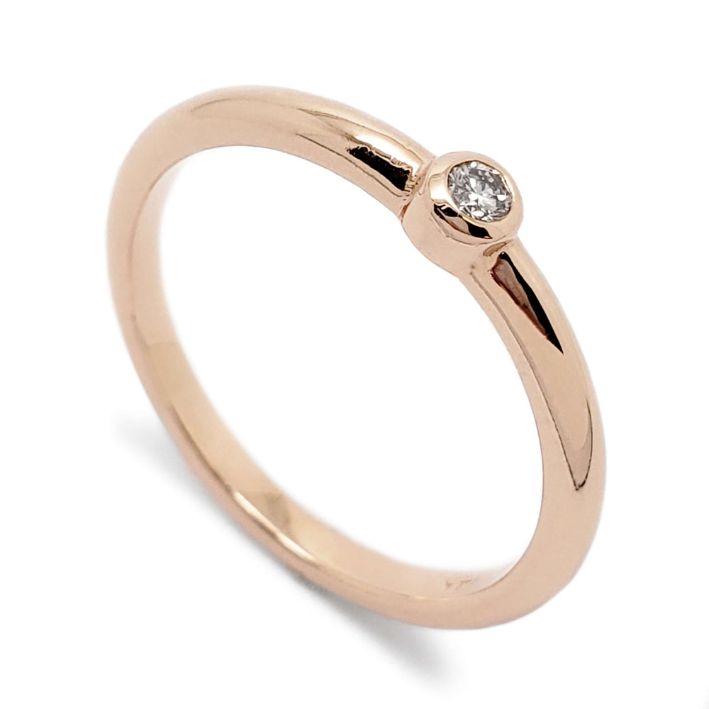 14kt rose gold ring with bezel set round Canadian diamond on white background