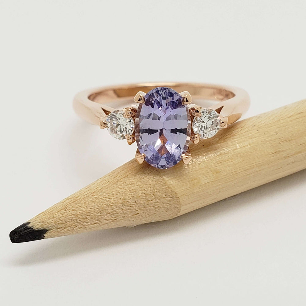 14kt rose gold ring with purple sapphire and lab-grown diamonds displayed on a pencil