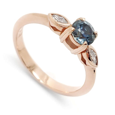 14kt rose gold ring with round blue Montana sapphire and two marquise diamonds
