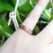 14kt rose gold scroll engraved diamond wedding ring worn on a hand