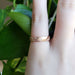 Hand wearing a 14kt rose gold topography textured wedding ring
