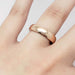 14kt rose gold wedding ring with low dome profile shown on a hand