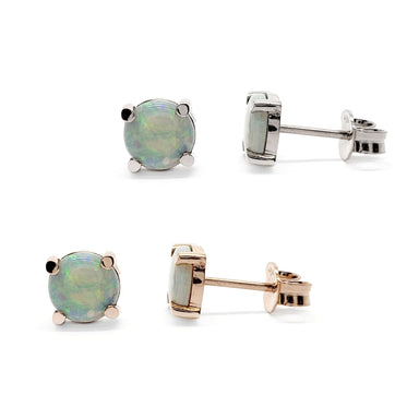 Pair of round cabochon opal stud earrings in 14kt white and rose gold settings on white background