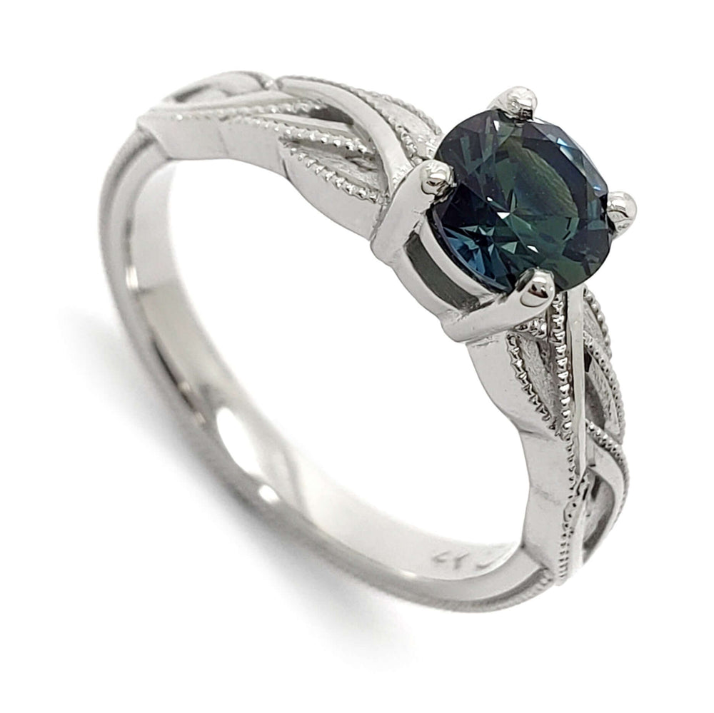 Handcrafted 14kt white gold ring with round blue Montana sapphire and interlace millgrain detail