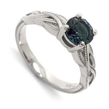 Handcrafted 14kt white gold ring with round blue Montana sapphire and interlace millgrain detail