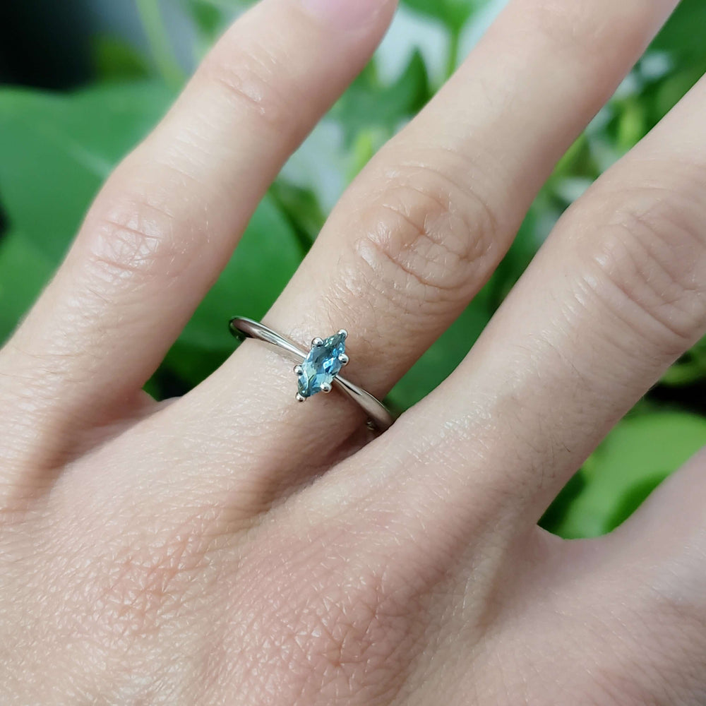 14kt white gold Montana sapphire marquise engagement ring worn on a hand