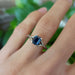 14kt white gold Montana sapphire ring worn on hand, green background