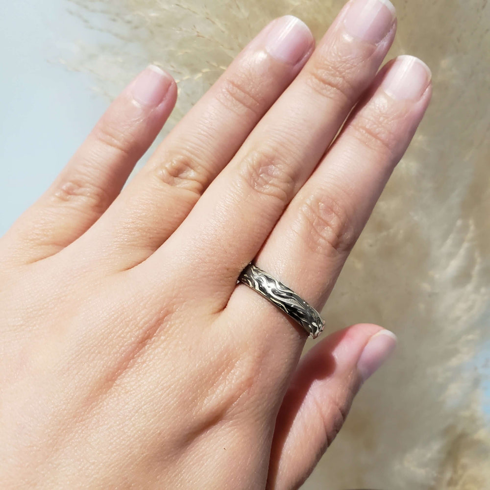 14kt white gold bark texture wedding ring worn on a hand