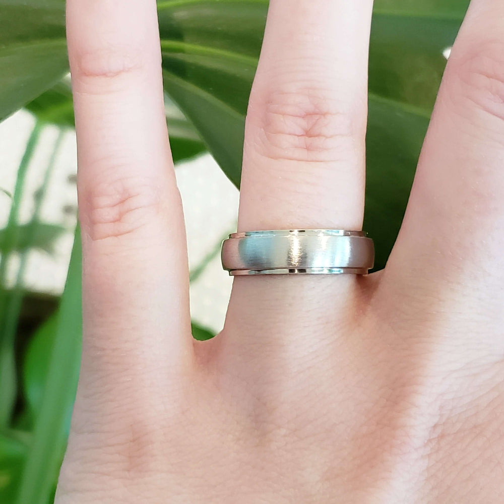 14kt white gold brushed wedding ring with domed step profile shown on hand
