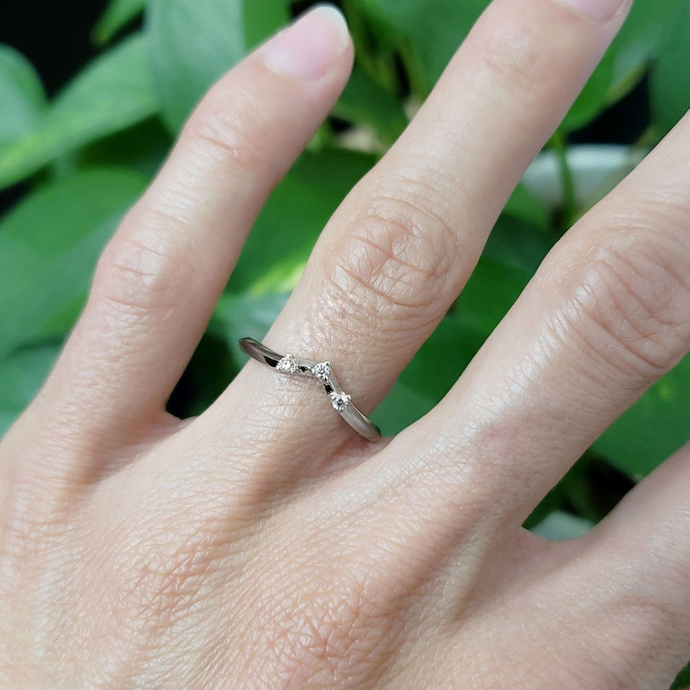 14kt white gold chevron diamond ring with three diamonds, worn on hand