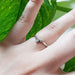 14kt white gold chevron diamond ring with pear cut diamond, worn on hand
