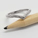 14kt white gold chevron wedding ring with engraved detail, displayed on a pencil