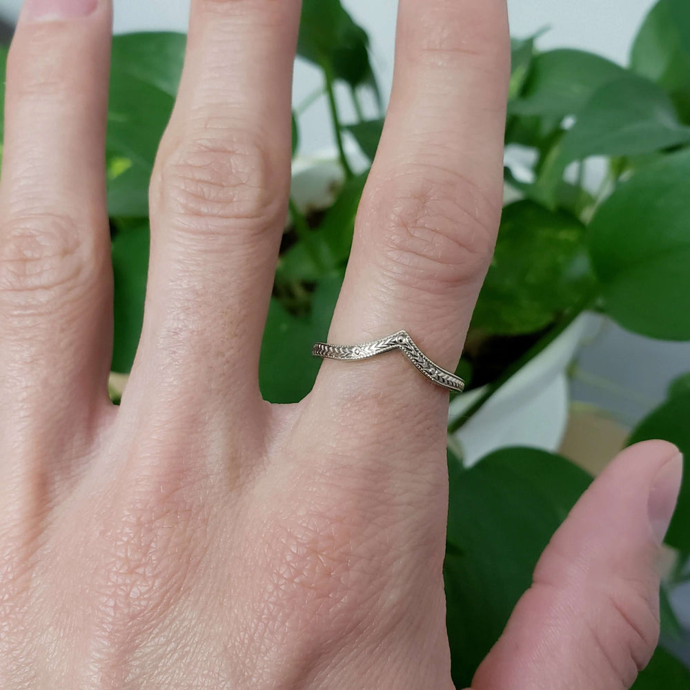 14kt white gold chevron wedding ring with engraving, worn on a hand