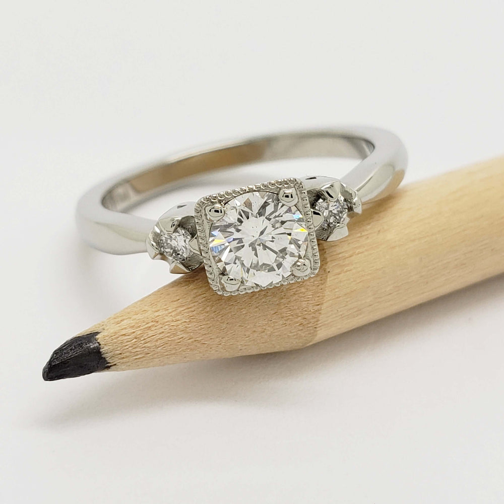 14kt white gold diamond ring with millgrain detail shown beside a pencil for scale