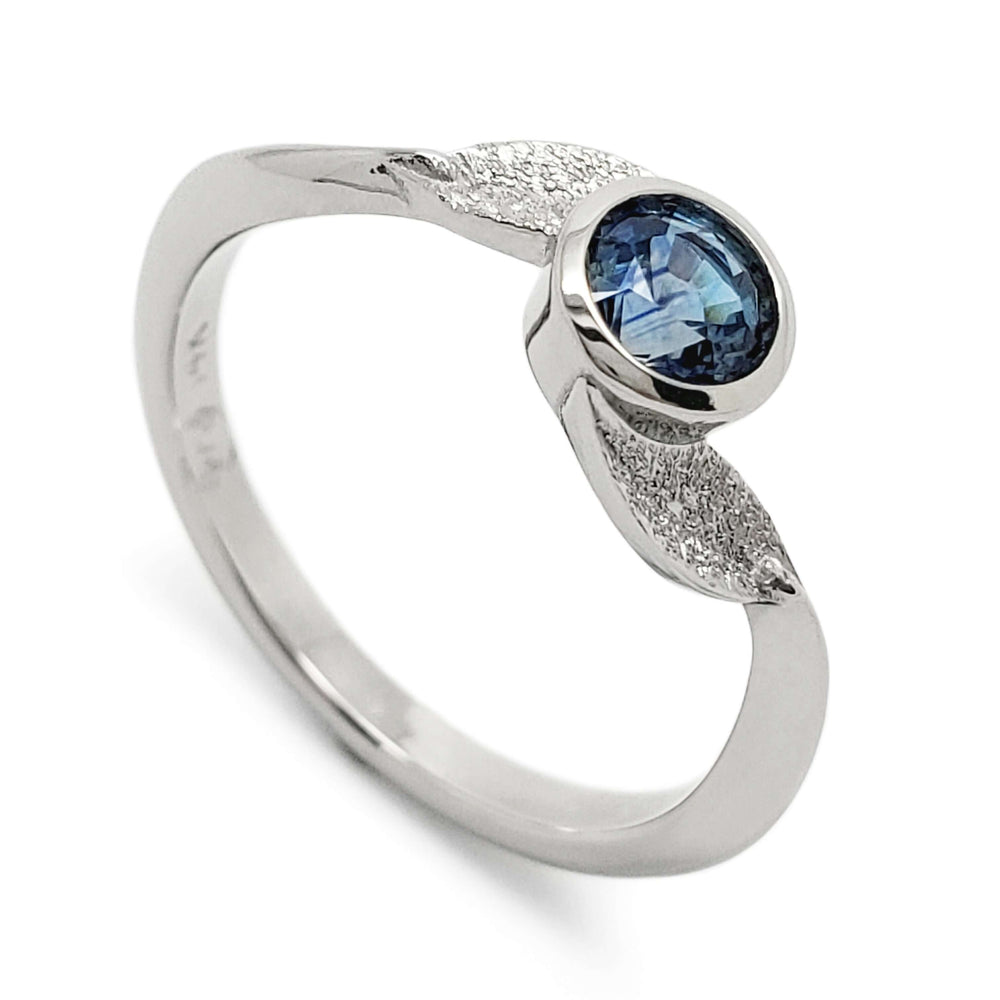 14kt white gold engagement ring with bezel-set blue Montana sapphire and leaf detail